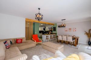 a living room with a couch and a dining room at Gül Evleri Çalış Beach Villa in Fethiye