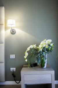 a vase of flowers on a table next to a lamp at Hotel Villa Borghi in Varano Borghi