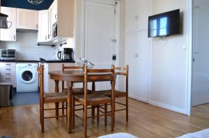 a kitchen with a table and chairs in a room at Appart à 2 pas de la plage - Centre d'Asnelles in Asnelles