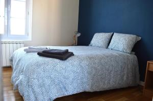 a blue bedroom with a bed with two pillows at Appart à 2 pas de la plage - Centre d'Asnelles in Asnelles