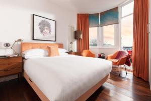 a bedroom with a large white bed and a desk at Chelsea House in Falmouth