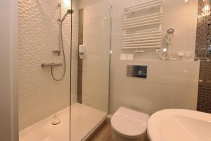 a bathroom with a shower and a toilet and a sink at Biały Dom Henlex Hotel Restauracja in Poznań