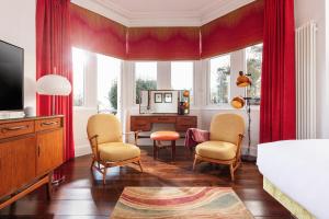 a bedroom with red curtains and a bed and a desk at Chelsea House in Falmouth