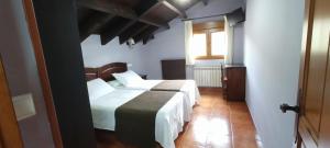 a bedroom with two beds and a window at Apartamentos El Castañeu in Corao +37 photos