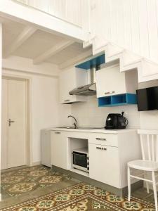 a white kitchen with a sink and a microwave at Casa Toti in Matino