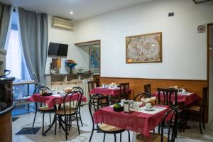 a restaurant with tables and chairs with red table cloth at Hotel Ferrarese in Rome