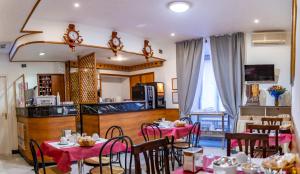a restaurant with tables and chairs and a kitchen at Hotel Ferrarese in Rome