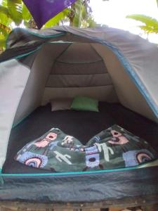 a tent with a bed in the middle at Camping Trópico de Capricórnio - Ilhabela in Ilhabela