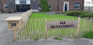 una recinzione di legno con un cartello che legge il rumore della strada di B&B Bouwmanshoeve a Burgh Haamstede