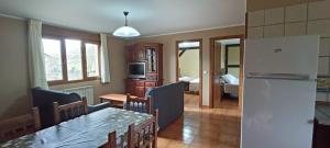 a kitchen and dining room with a table and a refrigerator at Apartamentos El Castañeu in Corao