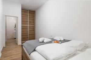 a white bedroom with a large bed with white pillows at Mary apartment #1 in Rijeka