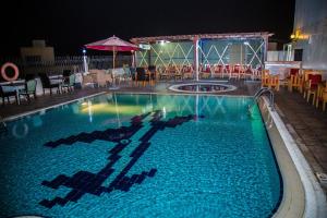 una piscina por la noche con mesas y sillas en Saffron Boutique Hotel, en Dubái