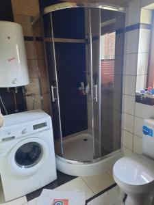 a bathroom with a shower and a washing machine at Wycinki domek in Osiek +29 photos