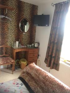 a bedroom with a bed and a dresser and a mirror at Laurel Lodge in Horncastle