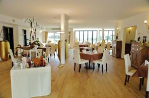 a dining room with white chairs and a table at Hochwälder Wohlfühlhotel in Losheim