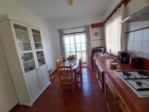 a kitchen with a counter and a table with chairs at Vv - Casa Clary -Finca Medina in Alojera