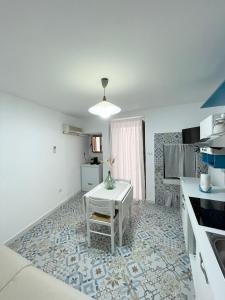 a kitchen with a white table and a white counter at Casa Toti in Matino