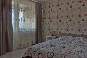 a bedroom with a bed and a large window at Estate I Apartamentai in Birštonas