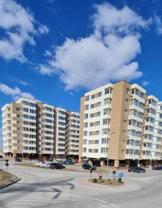 a parking lot with large apartment buildings in the background at Apartament Bacovia in Bacău