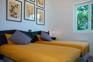 dos camas sentadas una al lado de la otra en una habitación en Villa Art Natura, en Juzet-de-Luchon