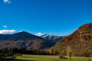 un campo verde con montañas al fondo en Villa Art Natura, en Juzet-de-Luchon