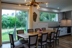 cocina y comedor con mesa de madera y sillas en Villa Art Natura, en Juzet-de-Luchon