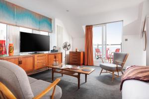 a living room with a couch and a tv at Chelsea House in Falmouth