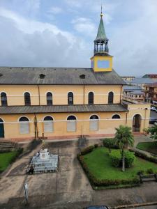 a large building with a clock tower on top of it at Hello Guyane (7), Grand Appartement Prestigieux F3 in Cayenne