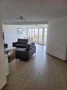 ein Wohnzimmer mit 2 Sofas und einem Tisch in der Unterkunft Hello Guyane (7), Grand Appartement Prestigieux F3 in Cayenne