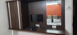 a mirror in a room with a tv and a bed at HOTEL S K PALACE in Mahabaleshwar
