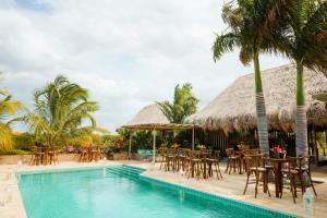 a resort with a pool and tables and chairs at Territorio Magico Dibulla in Dibulla