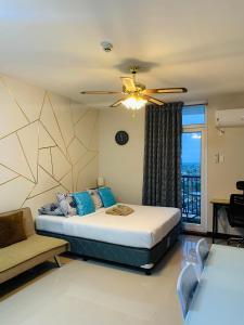 1 dormitorio con 1 cama y ventilador de techo en Quayside Condo near Airport, en Mactan