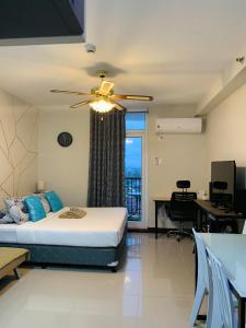 1 dormitorio con 1 cama y ventilador de techo en Quayside Condo near Airport, en Mactan