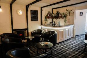 a bar with black leather chairs and a counter at The Sandpiper Guest House in Torquay