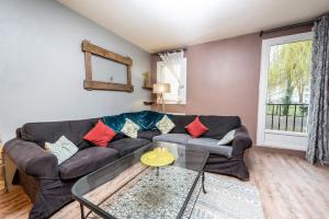 a living room with a couch and a glass table at Duplex cosy et contemporain avec parking privé in Amiens