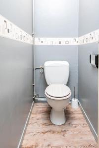 a white toilet in a bathroom with a wooden floor at Duplex cosy et contemporain avec parking privé in Amiens