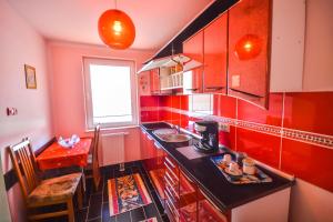 a kitchen with red walls and a black counter top at Pensiunea Caro in Deva