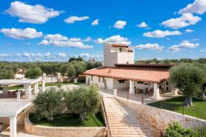 een uitzicht op een gebouw met een tuin en bomen bij WePuglia - Torre Nuova Luxury in Castellana Grotte