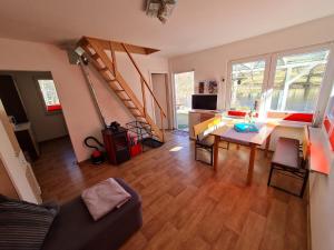 ein Wohnzimmer mit einem Sofa, einem Tisch und einer Treppe in der Unterkunft Ferienhaus direkt am Badesee Bungalow 11 Schönsee in Urnshausen
