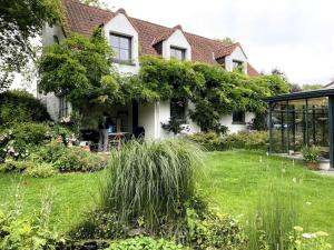 une maison blanche avec un jardin en face dans l'établissement Le Cottage, à Lasne
