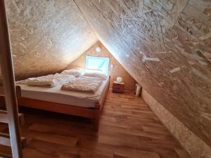 een slaapkamer met een bed op zolder bij Ferienhaus direkt am Badesee Bungalow 11 Schönsee in Urnshausen