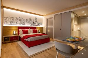 a bedroom with a red bed and a desk at NEW OPENING 2022 - Los Lorentes Hotel Bern City in Bern