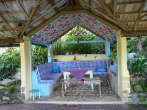 a covered patio with a blue couch and a table at Finca la Contenta in Jamao al Norte