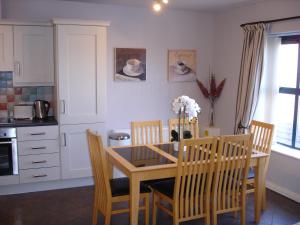 a kitchen with a dining room table and chairs at Apt 7A Waterfoot Apartment in Newcastle