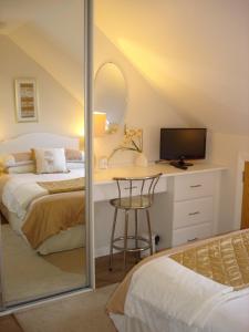 a bedroom with a bed and a desk with a mirror at Apt 7A Waterfoot Apartment in Newcastle