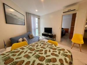 1 dormitorio con cama, sofá y TV en Beachfront Flat, en Florianópolis