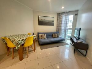 sala de estar con mesa y sofá en Beachfront Flat, en Florianópolis