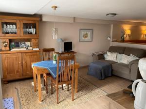 ein Wohnzimmer mit einem Tisch und einem Sofa in der Unterkunft Apartment,Wohnung & Zimmer 'Am Waldfreibad' in Much