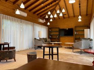 a living room with tables and chairs and a flat screen tv at The Postcard Hideaway, Netravali Wildlife Sanctuary, South Goa in Vichondrem