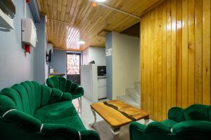 a room with green chairs and a table and a kitchen at Candy Hotel in Istanbul